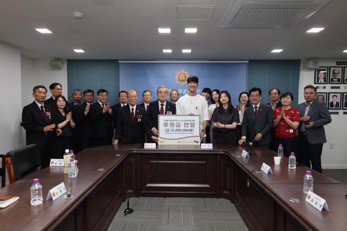 여행 유튜버 이상혁(앞줄 오른쪽 다섯째) 씨가 지난 4일 서울 강서구 대한민국무공수훈자회 창아홀에서 김정규 회장에게 보훈성금을 전달한 뒤 기념사진을 찍고 있다. 무공수훈자회 제공