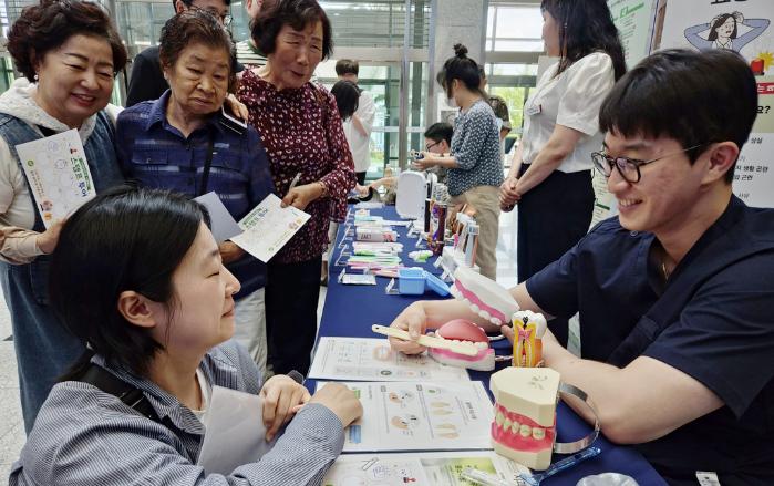 육군36보병사단 치과군의관이 구강보건의 날 행사에 참가한 지역주민에게 구강건강의 중요성에 대해 설명하고 있다. 부대 제공
