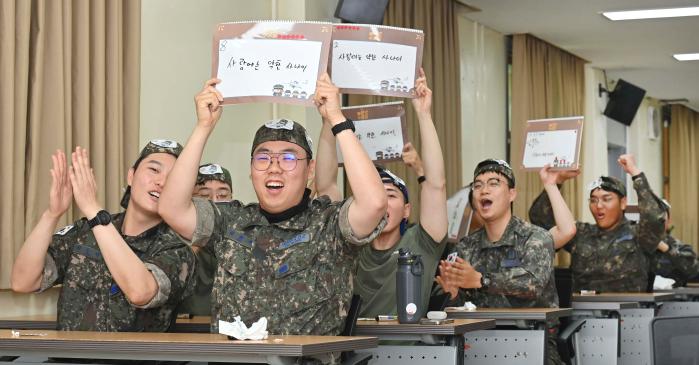 공군20전투비행단이 10일 기지 내 정훈교육장에서 진행한 군가 받아쓰기 경연대회 ‘용성 놀라운 수요일’에서 장병들이 정답판을 들어 보이고 있다. 사진 제공=김경률 원사
