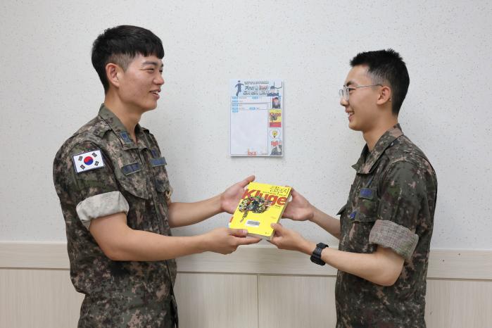 이원균(왼쪽) 공군1전비 정보통신대대장이 부대원에게 책을 추천하고 있다.