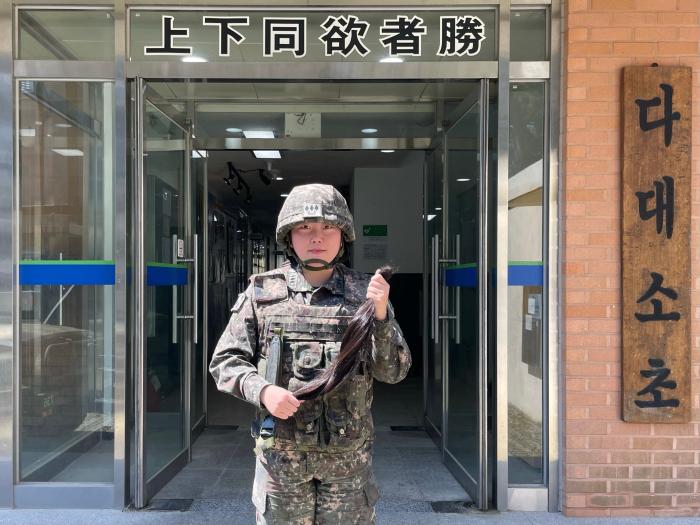 육군53보병사단 부산여단 이예담 대위가 소아암 환자를 돕기 위해 기른 머리카락을 자른 뒤 기념촬영을 하고 있다. 사진 제공=이태병 대위