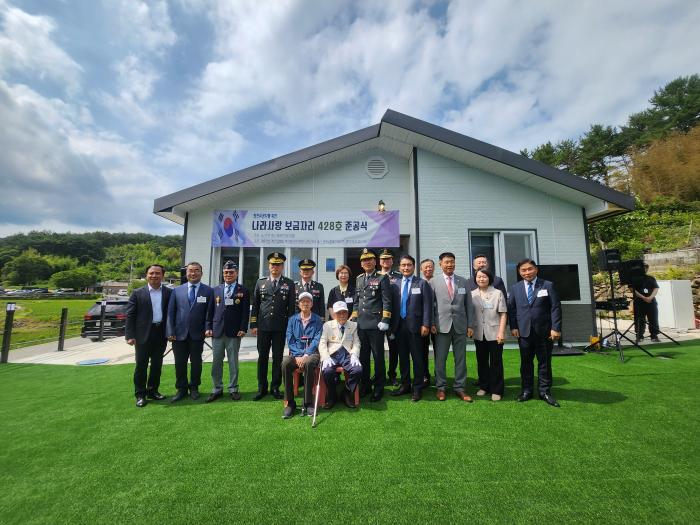육군인사사령부가 18일 개최한 나라사랑 보금자리 428호 준공식에서 6·25전쟁 참전유공자 윤성대 옹과 참석자들이 기념사진을 찍고 있다. 부대 제공