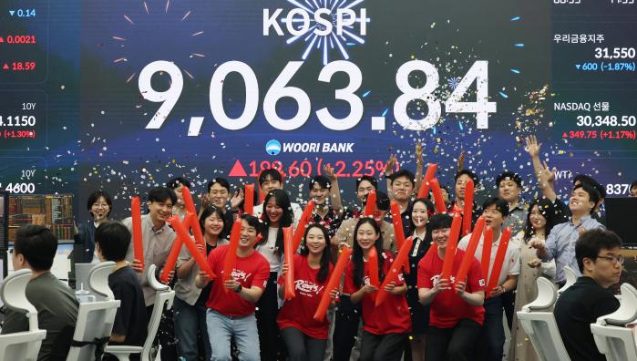 코스피가 사상 처음으로 종가 기준 9000선을 돌파하며 장을 마친 18일 서울 중구 우리은행 본점 딜링룸에서 직원들이 축하 세리머니를 하고 있다. 연합뉴스