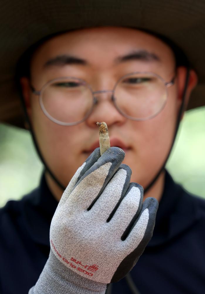 발굴한 총탄을 들여다보고 있는 장병.