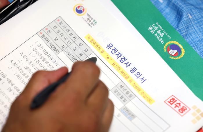 고 김대식 참전용사의 남동생 김만식 씨가 유전자 채취 동의서에 서명하고 있다.