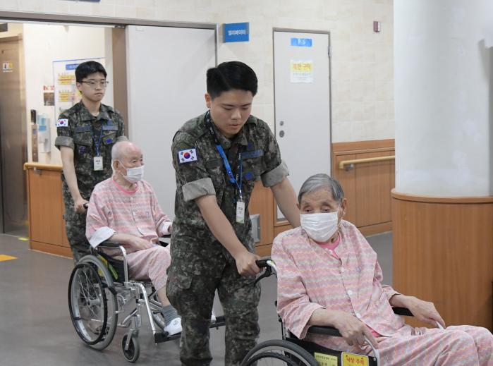 공군작전사령부 병 자율위원회 위원들이 25일 수원보훈요양원에서 국가유공자들에게 봉사활동을 하고 있다. 부대 제공