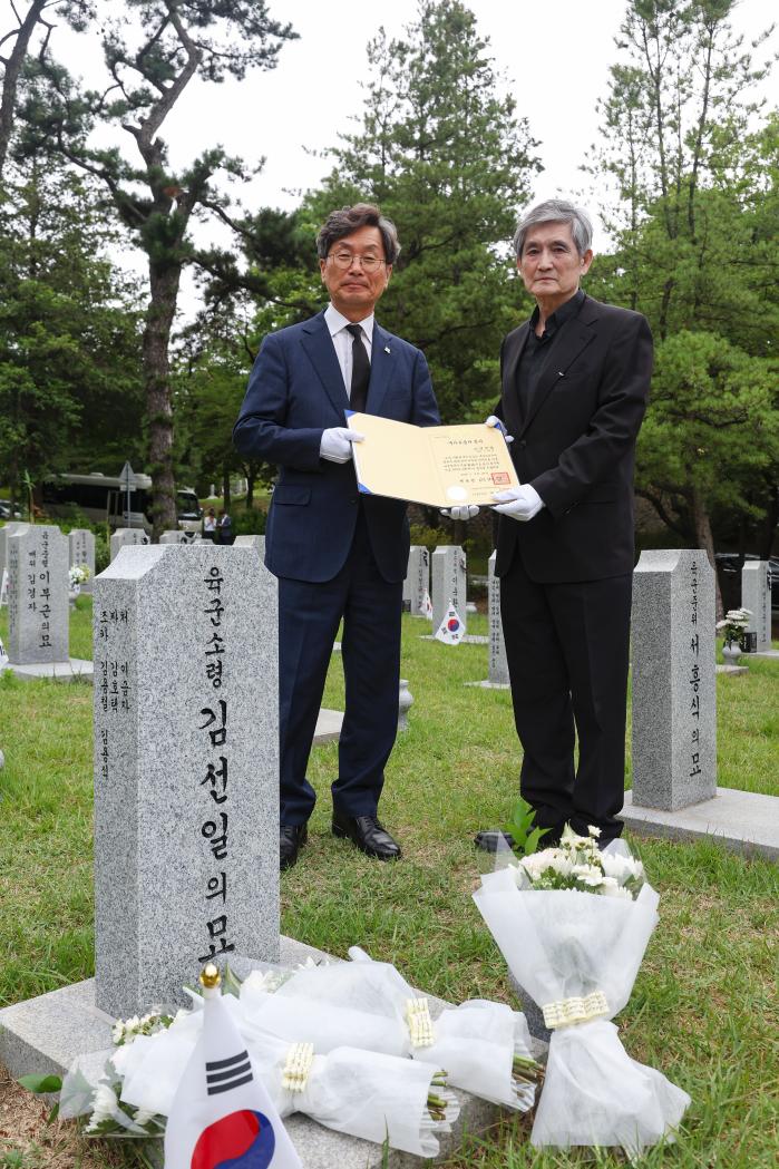 정일연(왼쪽) 국민권익위원장이 25일 서울 동작구 국립서울현충원에서 6·25전쟁 영웅 고 김선일 소령 추모식에서 유가족과 국가유공자 증서를 들고 기념촬영을 하고 있다. 이경원 기자