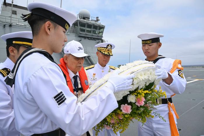 지난 26일 부산해군기지를 출항해 대한해협해전 해역 인근에 도착한 마라도함(LPH, 1만 4,500톤급)에서 참전용사 황상영(가운데) 옹과 장석용(오른쪽 둘째) 해군작전사령부 참모장이 해상헌화를 하고 있다.