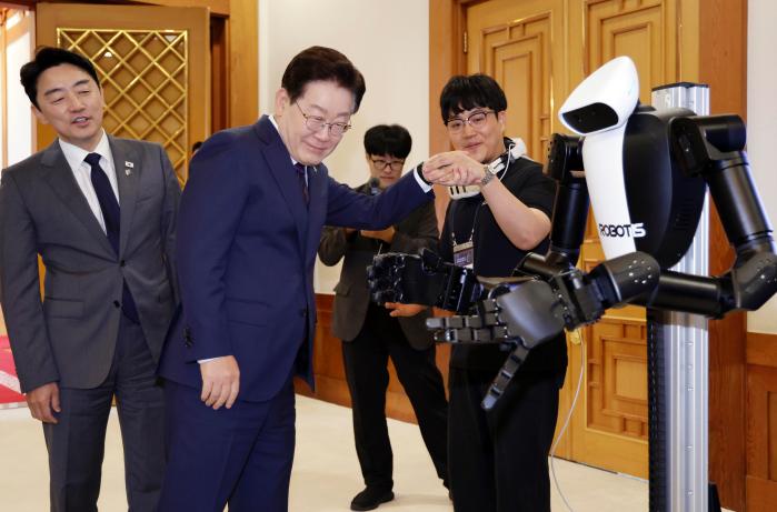 이재명 대통령이 지난 26일 청와대에서 열린 미래신안보 혁신기업 육성전략회의에 앞서 행사장에 전시된 휴머노이드 로봇을 살펴보고 있다. 연합뉴스
