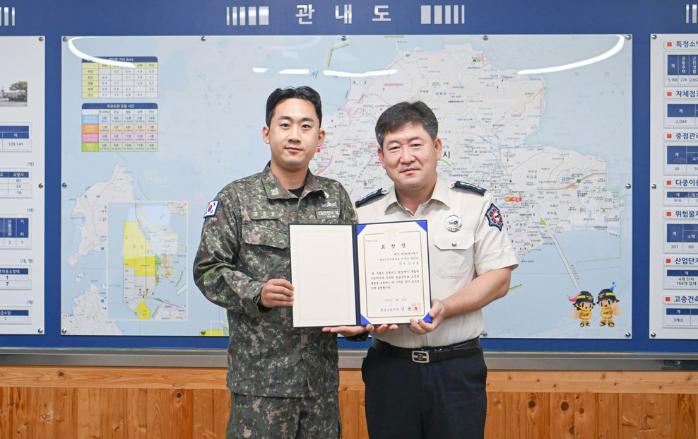 해군3함대 기지지원대대 김응호(왼쪽) 중사가 교통사고를 당한 초등학생을 응급처치해 생명을 구한 공로로 목포소방서장 표창장을 받고 있다. 부대 제공