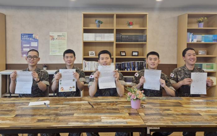 육군55보병사단 양평대대에 감사와 응원의 메시지를 담은 위문편지를 작성한 평택 가내초등학교 학생들과 학생들에게 답장을 써준 장병들. 부대 제공