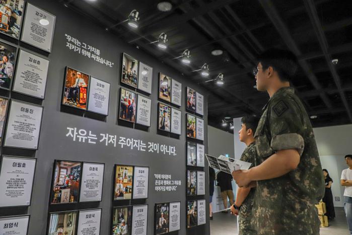 육군2기갑여단 정훈관계관 워크숍 참석자들이 서울 용산구 전쟁기념관에서 라미 작가의 사진전을 관람하고 있다. 부대 제공
