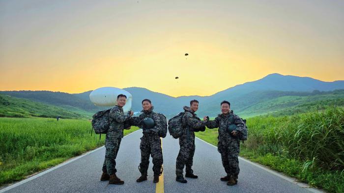 3일 육군특수전학교에서 동반강하를 성공적으로 마친 두 부자가 기념촬영을 하고 있다. 왼쪽부터 김원배 원사, 김찬솔 생도, 사현서 생도, 사인우 대령. 부대 제공
