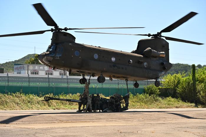 육군수도기계화보병사단이 12일 전개한 한미 연합 화물공수 훈련에서 장병들이 CH-47 시누크 헬기를 이용해 155㎜ 곡사포를 공수인양하고 있다. 사진 제공=임현정 중사