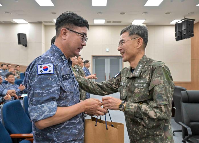 김경률(오른쪽) 해군참모총장이 13일 해군진해기지사령부 운주관에서 열린 함정 근무 부사관 복무여건 개선을 위한 소통간담회에서 30년 이상 함정에 근무한 정병주(원사) 대청함 조타장을 격려하고 있다. 해군 제공