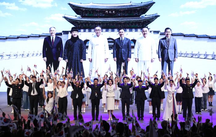 이재명 대통령과 김혜경 여사가 지난 15일 열린 제81주년 광복절 경축식에서 참석자들과 만세삼창을 하고 있다. 인공지능(AI)으로 구현한 배경 영상에 독립운동가 조소앙·이회영·김구·안창호·정세권·김용관(왼쪽부터) 선생이 서 있다. 연합뉴스