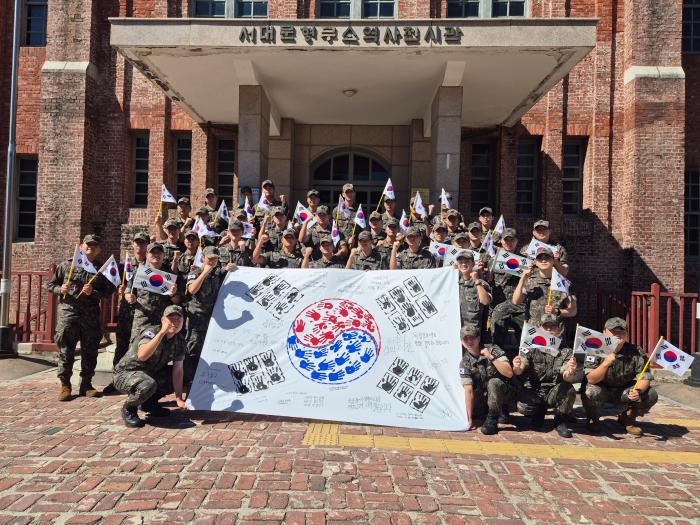 육군1포병여단 천경대대 장병들이 서대문형무소 앞에서 손도장으로 만든 태극기를 들고 독립운동가들의 정신을 되새기고 있다. 부대 제공