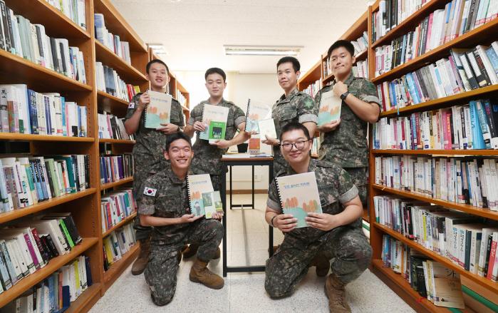 여단 화율대대 병영생활관 도서관에서 ‘청포 독(讀)파민 마라톤’ 참가 장병들이 도서 감상노트를 들고 포즈를 취하고 있다.