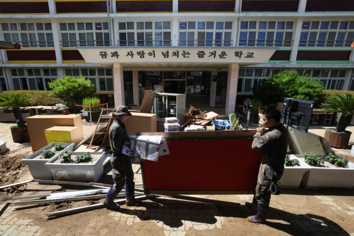 장평초등학교 운동장에서 비 피해를 당한 집기를 옮기는 장병들.