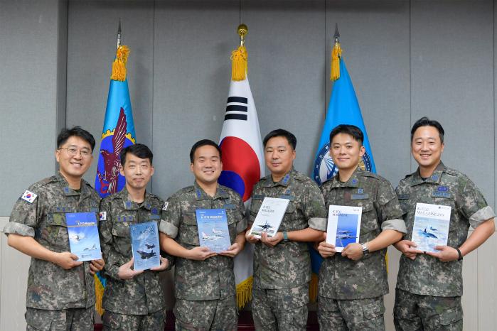 공군군수사령부 항공자원관리단 국제기술협력과 부서원들이 이제까지 발간된 K-TCG 매거진을 들고 기념사진을 촬영하고 있다. 부대 제공