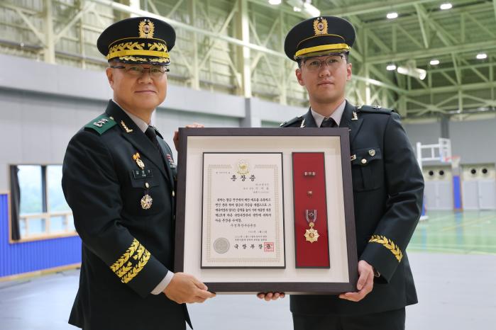 육군수도기계화보병사단이 개최한 고(故) 이기용 병장 화랑무공훈장 전도 수여식에서 고인의 손자인 수기사 백호대대 이한구(오른쪽) 소위가 김성구(소장) 사단장과 함께 훈장·훈장증을 들어보이고 있다. . 부대 제공