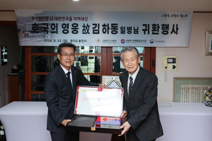 31일 전병희(왼쪽) 국방부유해발굴감식단장이 고 김하동 일병의 남동생 김하준 옹에게 호국의 얼 함을 전달하고 있다. 국방부 제공
