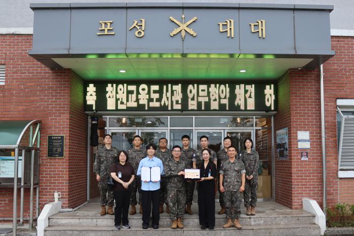 제갈성진(앞줄 가운데) 육군6보병사단 포성대대장과 김민서(앞줄 오른쪽 둘째) 철원교육도서관장 등 관계자들이 1일 업무협약을 맺은 뒤 협약서를 들고 기념사진을 찍고 있다. 사진 제공=김길운 중위